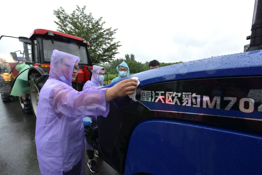 yl34511线路中心毕业生擦拭拖拉机（刘涛 摄）